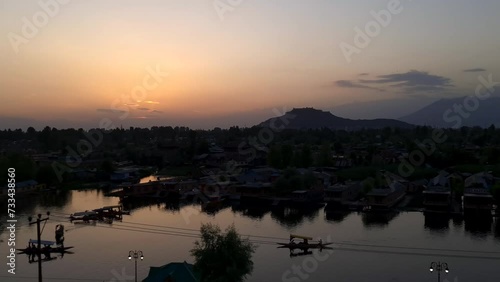 Dal lake sunset. Dal is a lake in Srinagar, the summer capital of Jammu and Kashmir, India. It is an urban lake. Boat ride and two persons in boat during coronavirus lockdown cover 19 photo