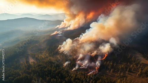 Overview photograph of large scale forest fire, dramatic wild fire engulfing forest seen from above. Effects of climate change on forests.