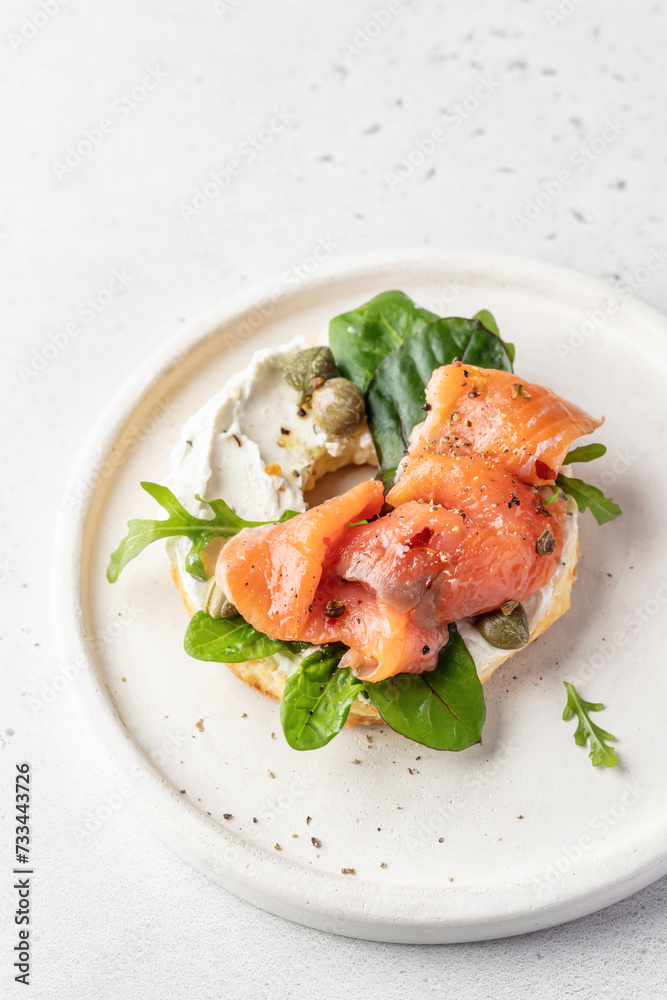 Homemade bagel sandwich with smoked salmon, cream cheese, capers and spinach for healthy breakfast isolated on white background top view Homemade bagel sandwich with smoked salmon, cream cheese, capers and spinach for healthy breakfast isolated on white background top view