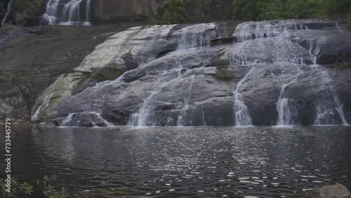 Temburun waterfall in Tarempa, Anambas Islands, Riau Archipelago, Indonesia surrounded by tropical forest. Multi layered waterfall cascade and rocky river stream. photo