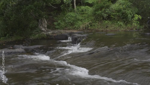 Temburun waterfall in Tarempa, Anambas Islands, Riau Archipelago, Indonesia surrounded by tropical forest. Multi layered waterfall cascade and rocky river stream. photo