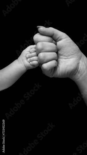 Touching two fists of mother and child in black and white colors.