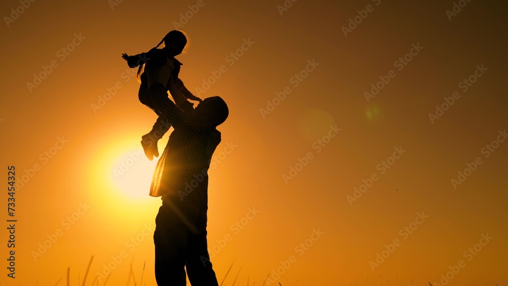 Father throws happy baby daughter into sky. Family game with child in outdoor. Dad is playing with child in park, girl dreams of fly. Happy family concept, childhood dream to fly. Dad kid daughter sun