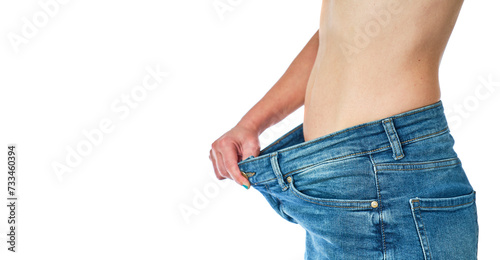 female abdomen with jeans that are too big for having lost a lot of weight on a white background photo