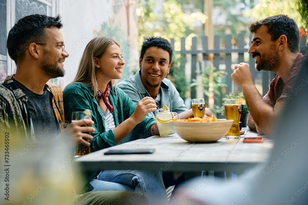 Obraz premium Happy woman enjoys in conversation with her friends while having drink in cafe.
