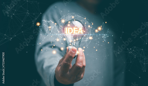 Innovative of new ideas concept. Businessman hand holding creative light bulb with IDEA words and global connecting network. New ideas for innovative technology and creativity. Inspiration.