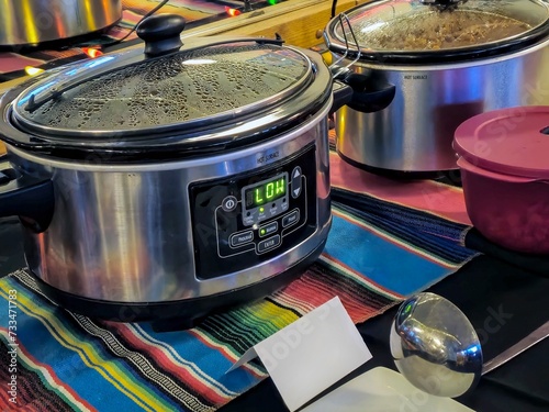 Crockpots on colorful striped cloth for chili cookoff