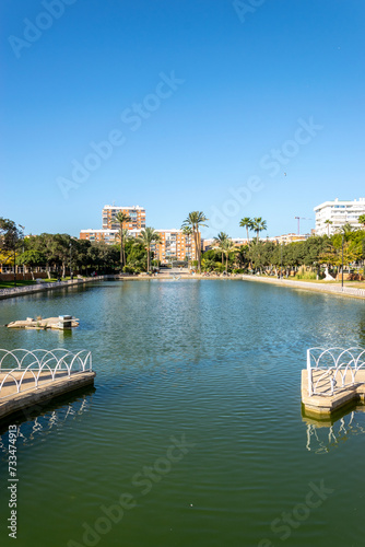 A large city park located around a picturesque lake. Malaga, Andalusia, Spain. The park has picnic areas and works of art.