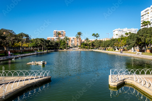 A large city park located around a picturesque lake. Malaga, Andalusia, Spain. The park has picnic areas and works of art. © Iwona