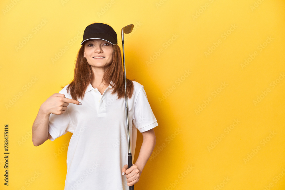 Redhead golfer with club and cap, studio shot person pointing by hand to a shirt copy space, proud and confident Redhead golfer with club and cap, studio shot person pointing by hand to a shirt copy space, proud and confident