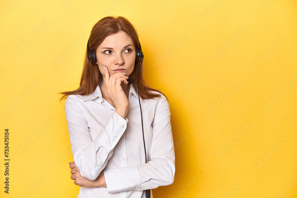 Call center redhead in white shirt, headphones on looking sideways with doubtful and skeptical expression. Call center redhead in white shirt, headphones on looking sideways with doubtful and skeptical expression.