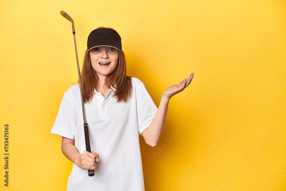Redhead golfer with club and cap, studio shot receiving a pleasant surprise, excited and raising hands. Redhead golfer with club and cap, studio shot receiving a pleasant surprise, excited and raising hands.