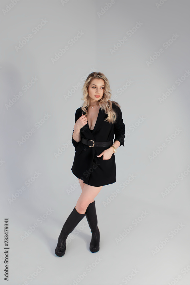 portrait of a person, Beautiful sexy blonde posing in a black business suit and boots portrait of a person, Beautiful sexy blonde posing in a black business suit and boots