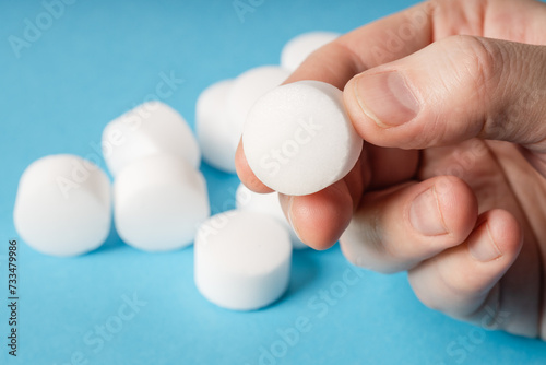 Konstfotografi White salt tablets for softening water in a softener on a blue background