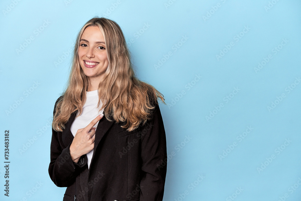 Caucasian woman in business jacket smiling and pointing aside, showing something at blank space. Caucasian woman in business jacket smiling and pointing aside, showing something at blank space.