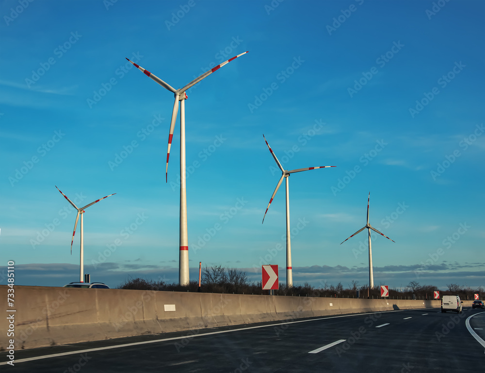 Wind farm park next to a road in Austria in sunny weather.