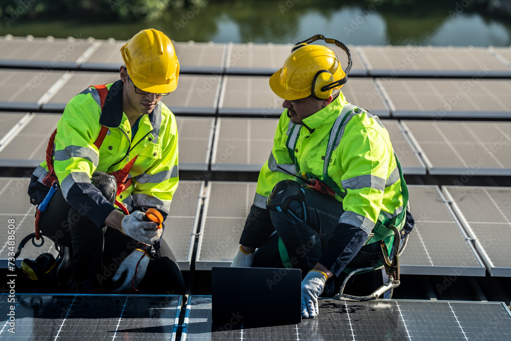 Worker Technicians are working to construct solar panels system on roof. Installing solar photovoltaic panel system. Men technicians carrying photovoltaic solar modules on roof. Worker Technicians are working to construct solar panels system on roof. Installing solar photovoltaic panel system. Men technicians carrying photovoltaic solar modules on roof.