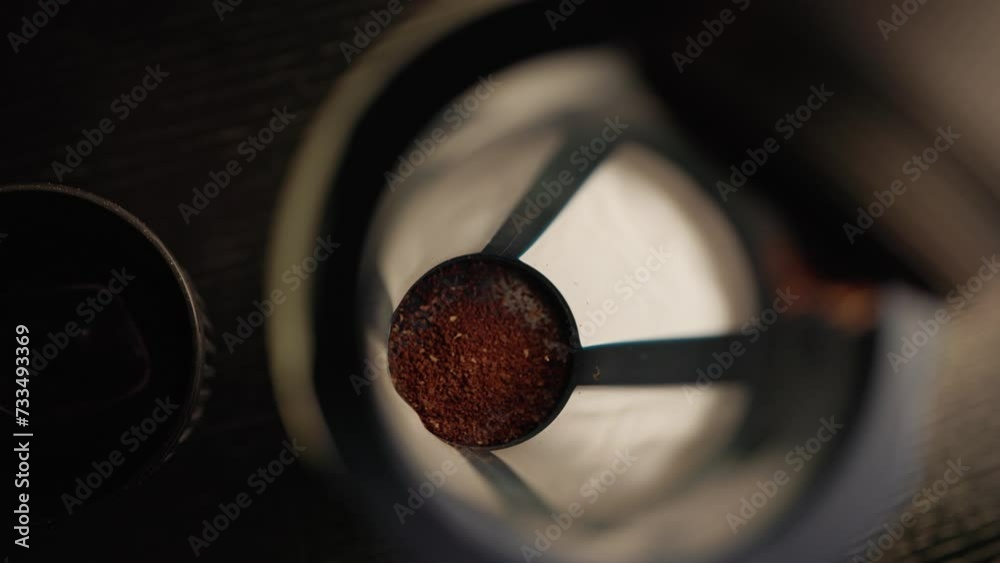 Macro close-up of coffee grounds being poured into cold brew canister