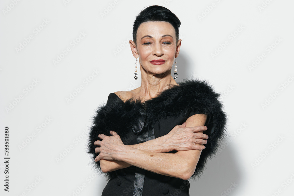 Elegant older woman in black dress with fur stole posing for camera in stylish vintage fashion portrait Elegant older woman in black dress with fur stole posing for camera in stylish vintage fashion portrait