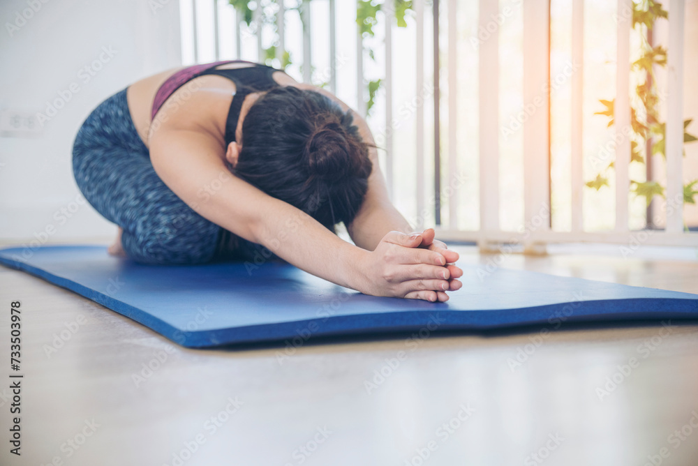 Fototapeta premium Women yoga meditation stretching back, arm meditate home fitness on floor. Happiness Young women doing yoga Balasana child pose. Wellness woman in sportswear meditate relaxation stretch health care