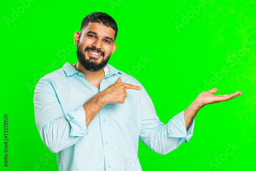 Indian bearded man showing thumbs up and pointing right empty place, advertising area for commercial text copy space for goods promotion advertisement. Guy isolated on chroma key background. Lifestyle
