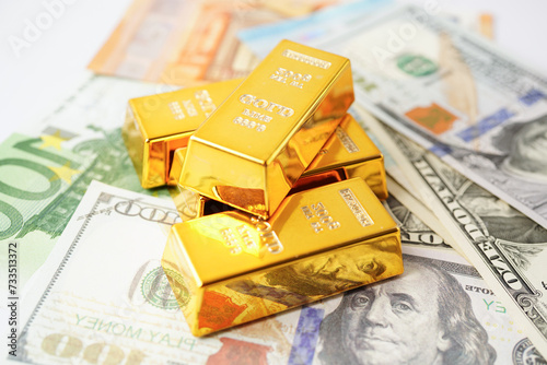 Gold bars with US dollar and Euro banknote money, finance trading investment business currency concept.