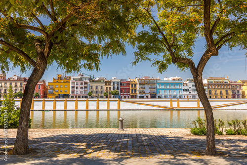 Vista de la calle Betis de Sevilla desde la orilla opuesta del río Guadalquivir, en un soleado día de verano photo