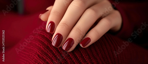Woman's nails with beautiful burgundy red manicure on beautiful red dress. AI generated