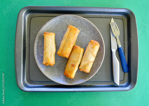 Delicious cheeseburger spring rolls on a plate after baking.