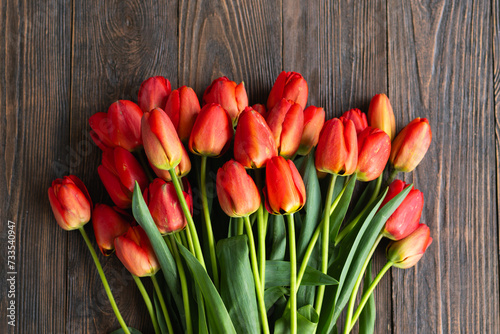 Fresh orange tulips on a wooden background. Springtime. Greeting card with copy space for Valentine's Day, Woman's Day and Mother's Day.