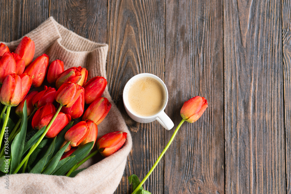 Fototapeta premium Fresh orange tulips and cappuccino mug with spring composition. Greeting card with copy space for Valentine's Day, Woman's Day and Mother's Day.