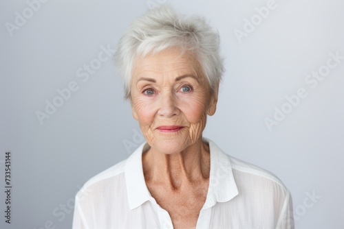 Portrait of a senior woman looking at the camera against grey background