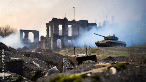 battle tank with smoke and fire in background. Destroyed building in town with burning structures after military attack during war.