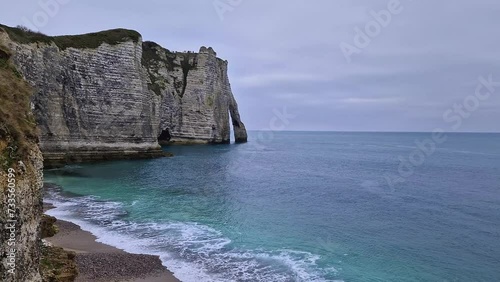 Sightseeing view to the wonderful cliffs of Etretat washed by the waves of the blue sea water, La Manche Channel. Famous Falaise d'Aval coastline in Normandy, France, Europe photo