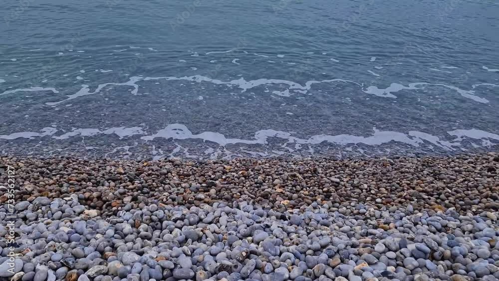 Pebble rocks beach and blue sea water texture Pebble rocks beach and blue sea water texture