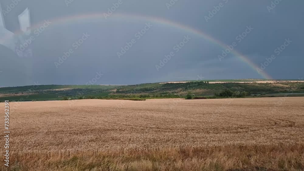 View out of the bus window while moving across rural crop fields with rainbow on the horizon. Road trip adventure, beautiful landscape View out of the bus window while moving across rural crop fields with rainbow on the horizon. Road trip adventure, beautiful landscape
