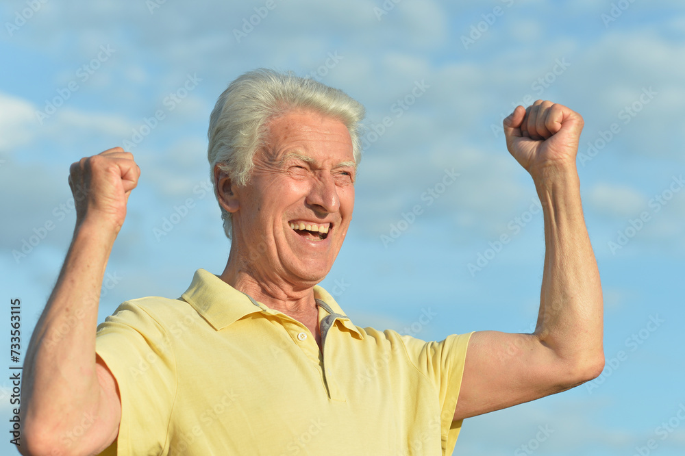 Naklejka premium Senior man posing on blue sky background
