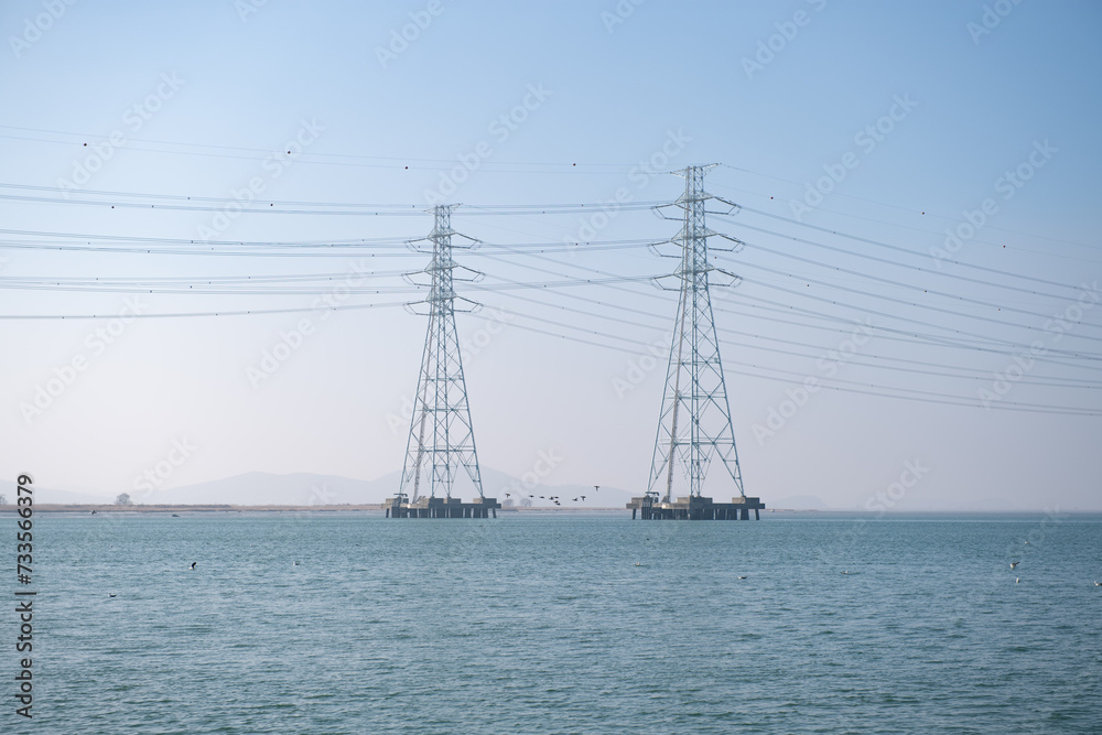 High-voltage transmission tower built on the sea where electricity flows
