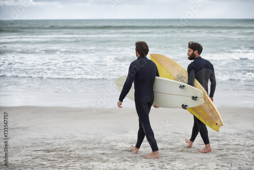 Man, friends and surfer at beach for waves, sport or exercise on sandy shore in outdoor fitness. Rear view of male person or people with surfboard for surfing on ocean coast, sea or water in nature