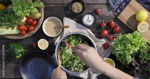 A woman cooking a variety of fresh salad vegetables, tomatoes, bell pepper, potato, fruits and dipping sauces, showcasing her hands preparation of a healthy salad, Delicious Vegetarian Dinner photo
