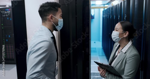 Covid, greeting and people with masks in office, server room and communication with safety from virus. IT, technician and engineer bump elbow in datacenter meeting with discussion of cyber risk photo