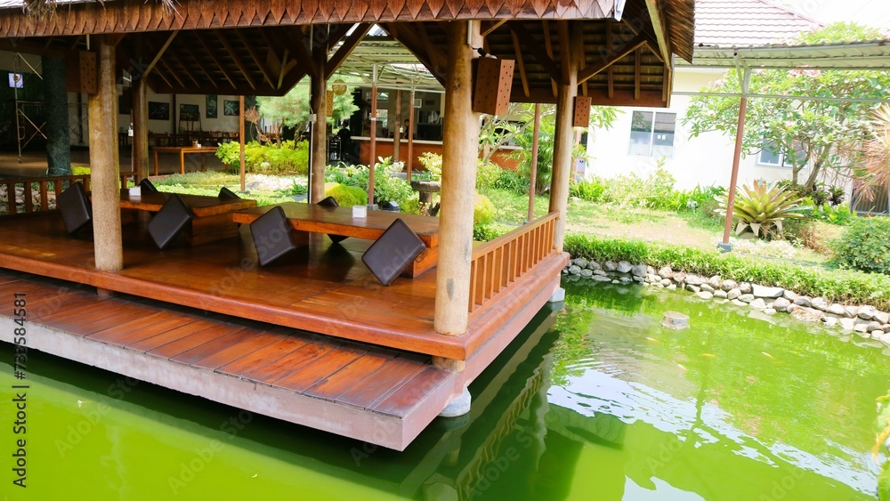 Wooden gazebo by the fish pond. Outdoor concept
