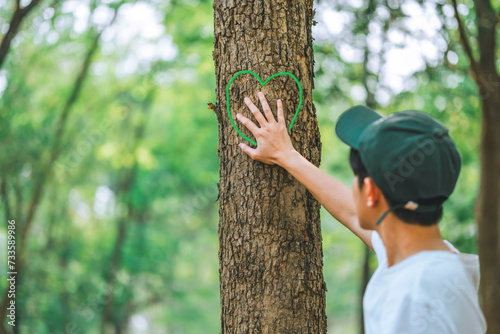 Human hand Hug and touching tree in the forest .people protect from deforestation and pollution or climate change Concept to love nature and tree . environment ecology and Earth Day concept