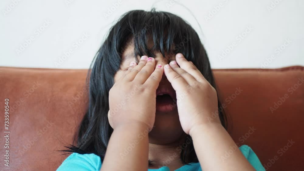 a upset child girl cover her face with hand a upset child girl cover her face with hand