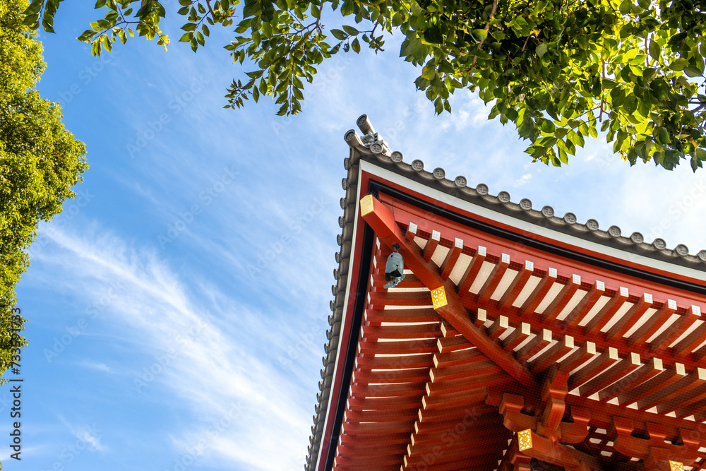 Details of corner of Japanese traditional temple roof with blue sky and tree, copy space Details of corner of Japanese traditional temple roof with blue sky and tree, copy space