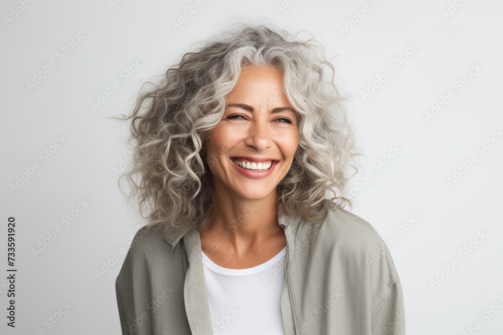 Portrait of smiling senior woman with curly hair, isolated on white background