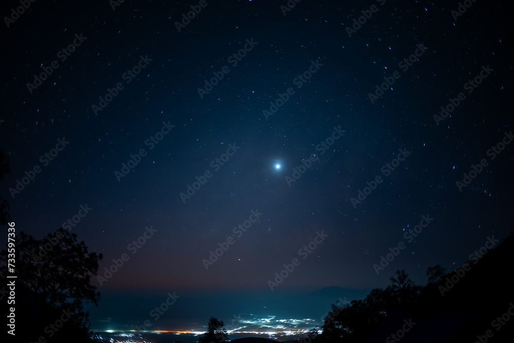 travel and people activity concept with star in the night with tree on mountain and lighting of city background