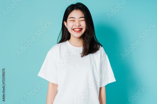 Studio shot of a young Asian woman with blank white t-shirt. T-shirt mockup design © Thuy Nguyen
