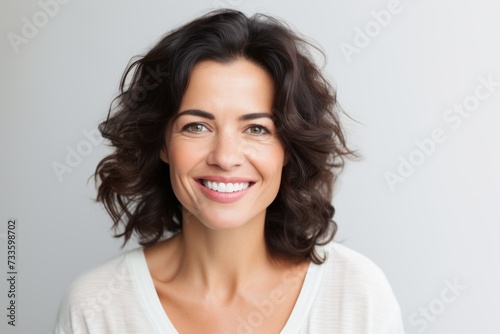 Portrait of happy smiling young beautiful woman  over grey background.