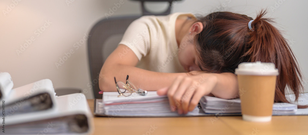 Stressed Asian woman having Tired and Sleepy while working, female businesswoman having headache at office, Exhausted woman with documents folder stack at home late night. Overworked and Overtime Stressed Asian woman having Tired and Sleepy while working, female businesswoman having headache at office, Exhausted woman with documents folder stack at home late night. Overworked and Overtime